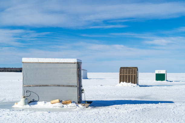 Ice fishing on a frozen harbor along the coast of Prince Edward Island, Canada.