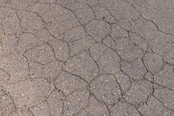 istock a part of a highway covered with cracked asphalt 2157795940