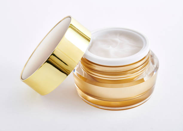 istock golden color cosmetic jar with open cap containing moisturizing cream, isolated on white background 2157798024