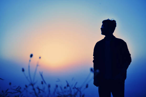 istock Silhouette of a young man at sunset 2157798125