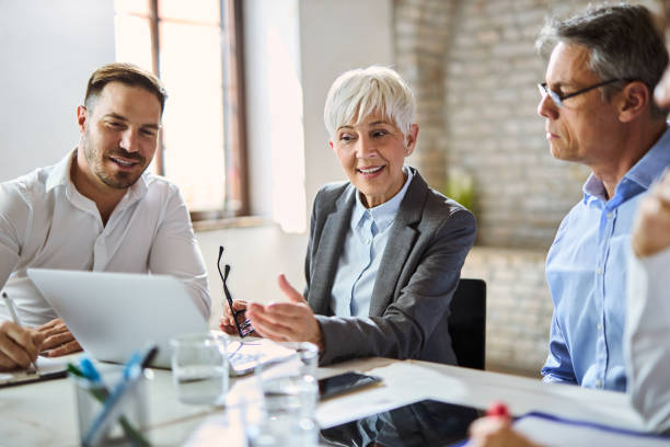 istock Team of business people talking while working on laptop in the office 2157798362