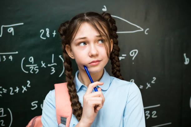 istock Girl student chatting with a pen, bringing it to her face 2157802552