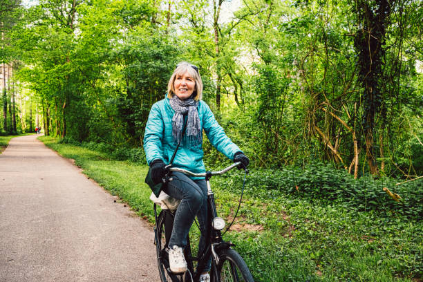 istock Senior woman cycling through forest trail 2157804764