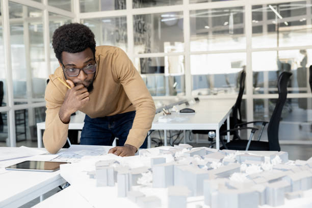 istock African american architect thinking on a miniature and looking thoughtful 2157806462