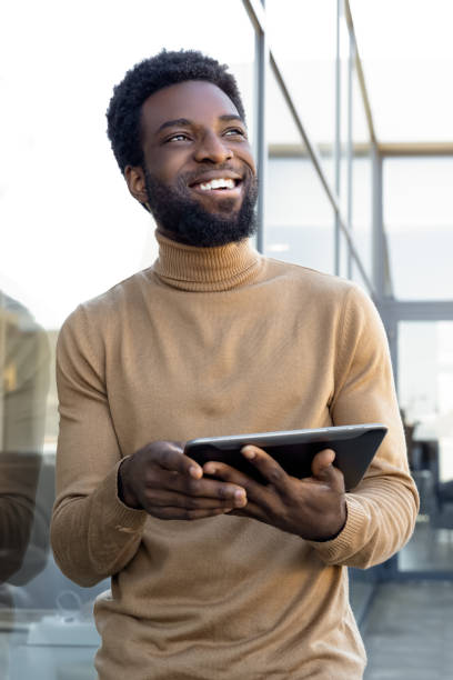 istock Smiling dark-skinned man in casual clothes with tablet in hands 2157806483