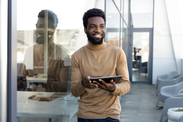istock Smiling dark-skinned man in casual clothes with tablet in hands 2157806493