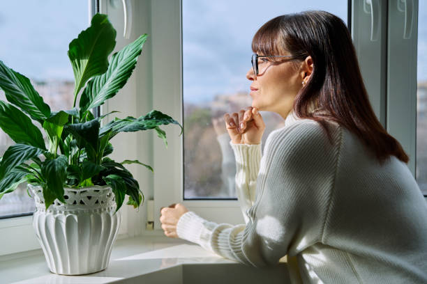 istock Beautiful happy middle aged woman looking out the window 2157806527