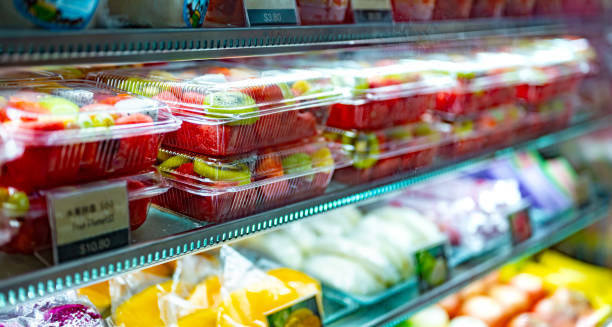 Plastic boxes with fresh fruits in a commercial refrigerator