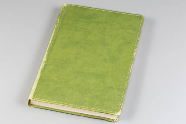 istock Closed old green shabby book on a gray background 2157809096