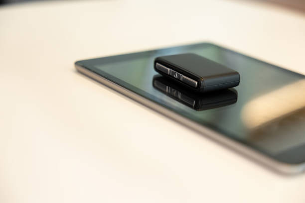 Gadget and car key. Tablet and car keys laying on the table