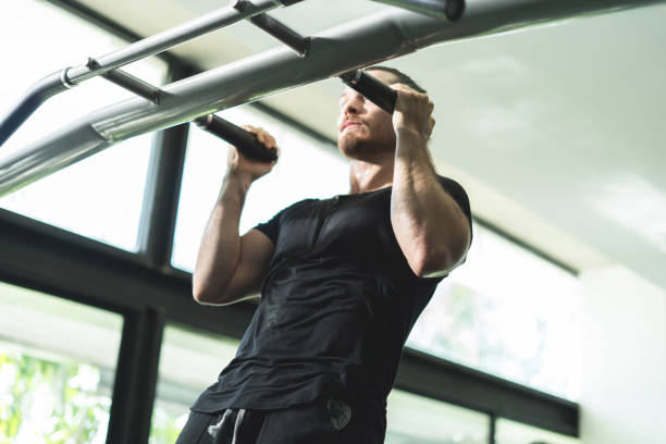 istock A man is hanging from a bar and doing pull ups. Concept of strength and determination as the man works to complete his workout 2157811862