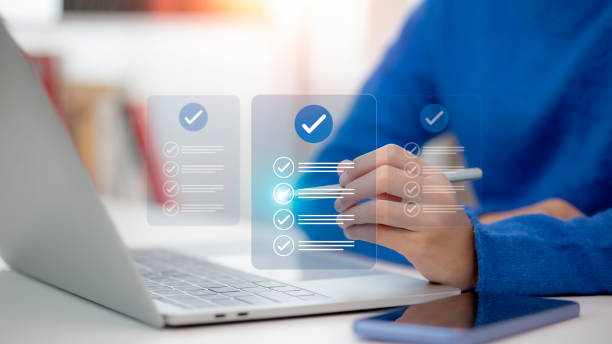 istock Women touching a virtual screen to tick mark documents for online approval. Prepare, check, and approve concepts. Document management is paperless, ensuring quality assurance and ERP management. 2157815031