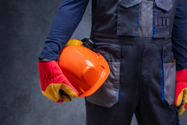 istock Close up of a worker, builder holding a helmet against dark wall. 2157815043