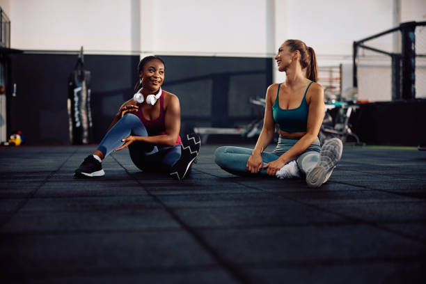 istock Young sportswomen talking while relaxing after working out in a gym. 2157815324