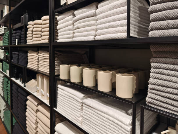 A stack of white towels neatly arranged on a black shelf stock photo