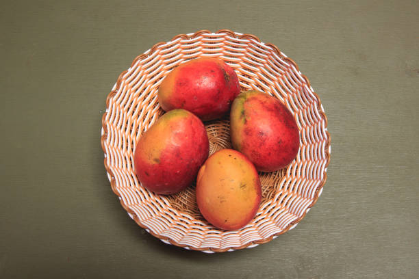 A close-up shot of hands spreading a perfectly ripe mango fruit with neatly sliced grid lines, emphasizing its vibrant color and natural texture. The image promotes healthy food choices and showcases the beauty of tropical fruits, perfect for food and wellness content.