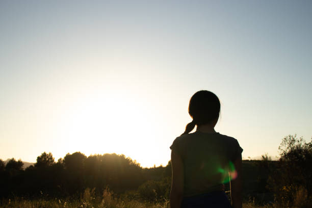 Silhouette of a young beautiful female on a summer walk during golden hour in the spanish village El Papiol, near to Barcelona