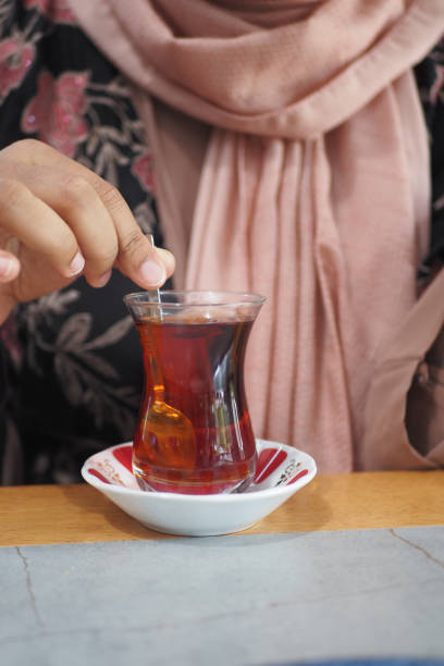 istock woman drinking Traditional turkish tea on white table . 2157821603