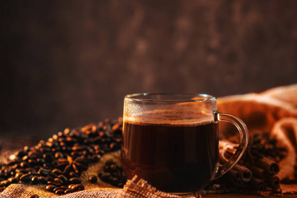 istock freshly brewed espresso coffee in a glass cup , roasted coffee beans on the table 2157824206