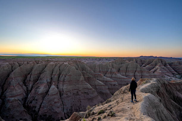 istock Hiker Enjoying a Vibrant Sunrise Over Panorama Point's Beautiful Geological Rock Formations in Badlands National Park in South Dakota USA 2157827800