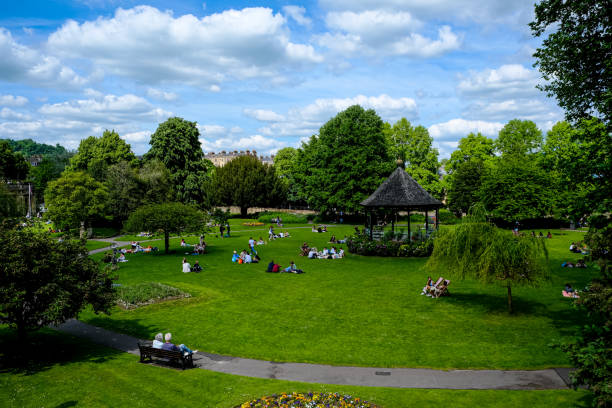 Bath, UK - 25.05.2024. View of the Parade Gardens in Bath, England. Sunny summer day. People are sunbathing and having picnic on a green grass