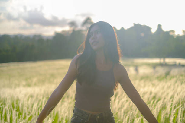 Cheerful Asian girl playing among the grass
