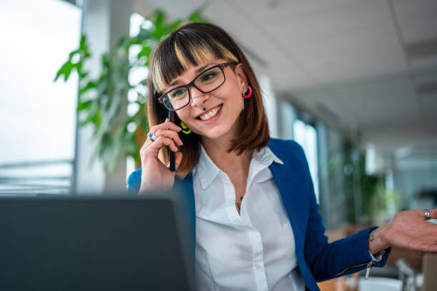 istock Professional Caucasian Female Engaged in Phone Conversation While Working on Laptop in Office 2157833142