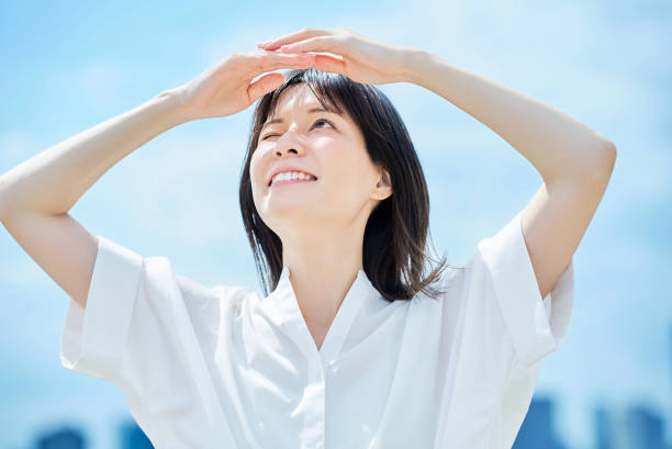 istock Young woman looking up at the sky 2157834830
