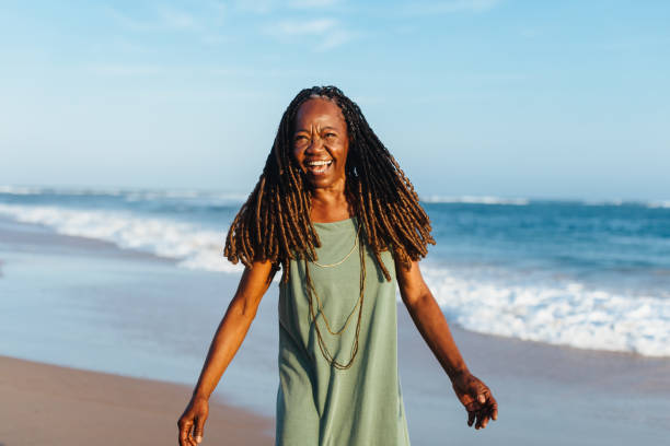 istock Elderly woman with braids smiling at the beach during sunset 2157837722