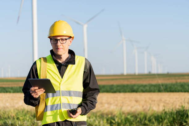 istock Engineer with digital tablet works on a field of wind turbines 2157840086