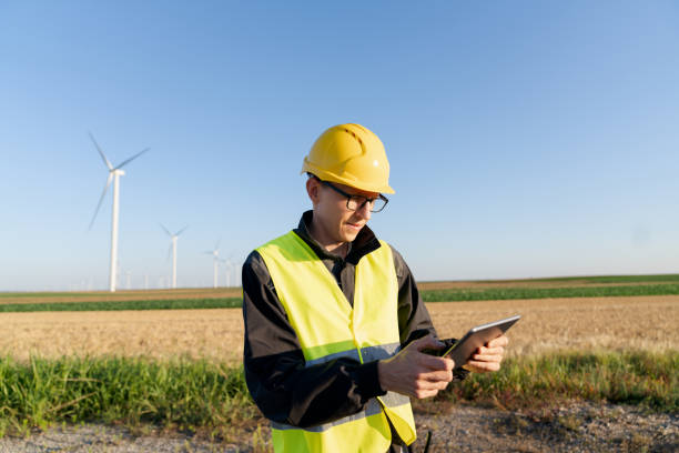 istock Engineer with digital tablet works on a field of wind turbines 2157841014