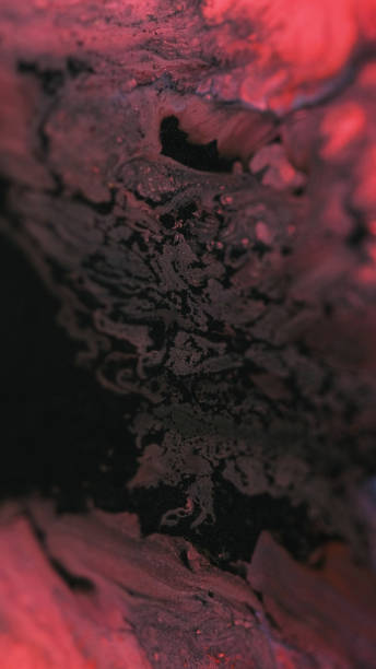 istock Shiny ink spill paint liquid black red glitter mix 2157841269