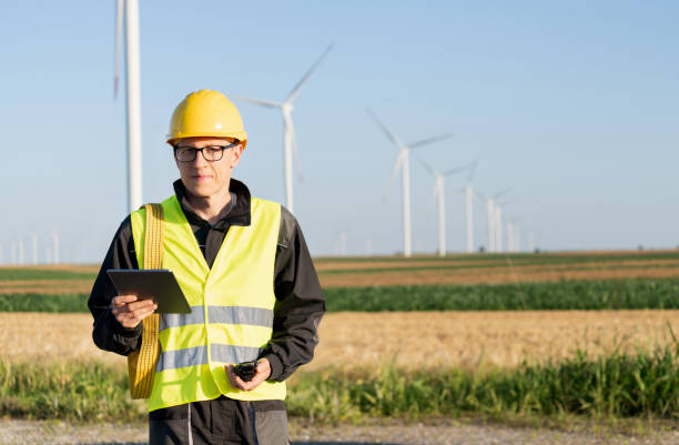 istock Engineer with digital tablet works on a field of wind turbines 2157841712