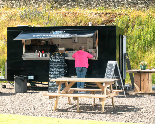 Customer, Silver Darlings, Tarbert Loch Fyne, Scotland A woman customer at the Silver Darlings fresh seafood takeaway food stall in Tarbert, Loch Fyne, Argyll and Bute, Scotland. loch fyne stock pictures, royalty-free photos & images