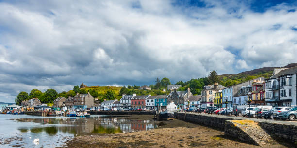 Part of the waterfront of Tarbert, Loch Fyne: Scotland Part of the waterfront of Tarbert, Loch Fyne, in Argyll and Bute, Scotland. It is located on East Loch Tarbert, which is an inlet of Loch Fyne. Formerly a strategic stronghold, it became a fishing town and is now a tourist base for exploring Kintyre and Knapdale. The 16th century towerhouse of the 13th century Bruce's Castle can be seen in the background. loch fyne stock pictures, royalty-free photos & images