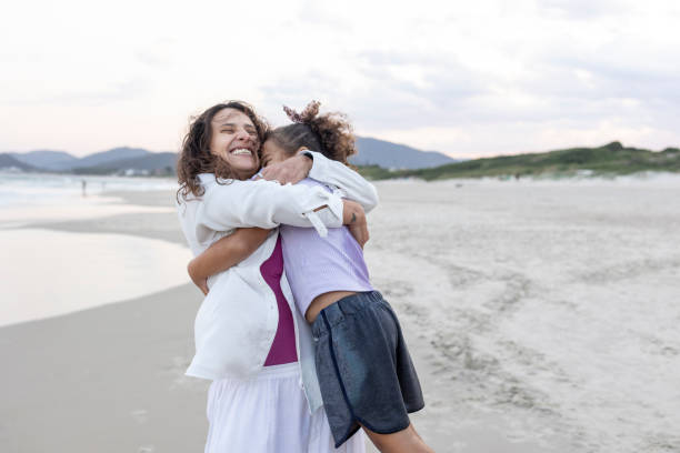 istock Daughter hugs her mother on the beach 2157850583