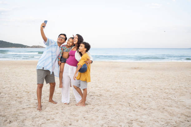 istock Latin family taking a selfie on the beach 2157850653