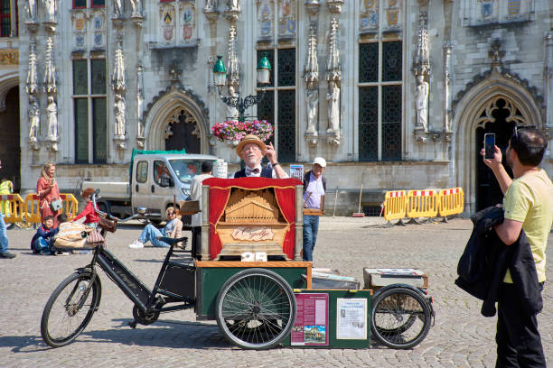 Coimbra, Portugal, 30 April 2019. A street musical, plays the piano accordion, with his dog sitting next to him in the streets of Coimbra. Coimbra is the fourth largest city in Portugal.
