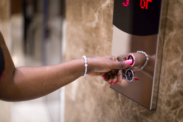 istock African black woman pressing the elevator button in a hotel lobby 2157851854