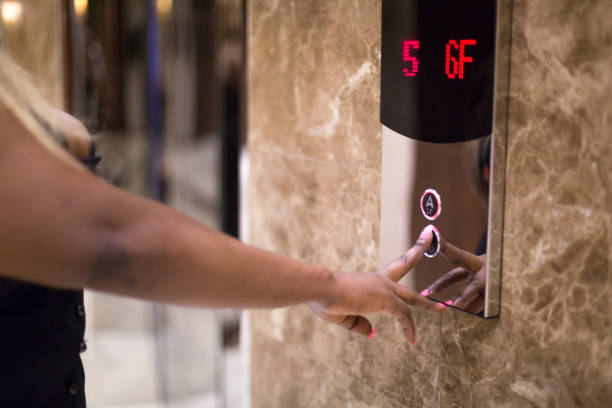 istock African black woman pressing the elevator button in a hotel lobby 2157851909