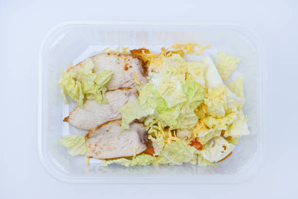 istock Caesar salad with meat and vegetables in a plastic container. A light breakfast. 2157852090