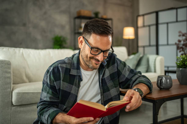 istock A man is casually reading a book in his home, he is on a well-deserved break from hard work in his office 2157854423