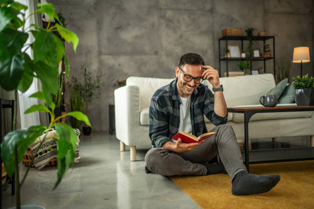 istock A man is casually reading a book in his home, he is on a well-deserved break from hard work in his office 2157854437
