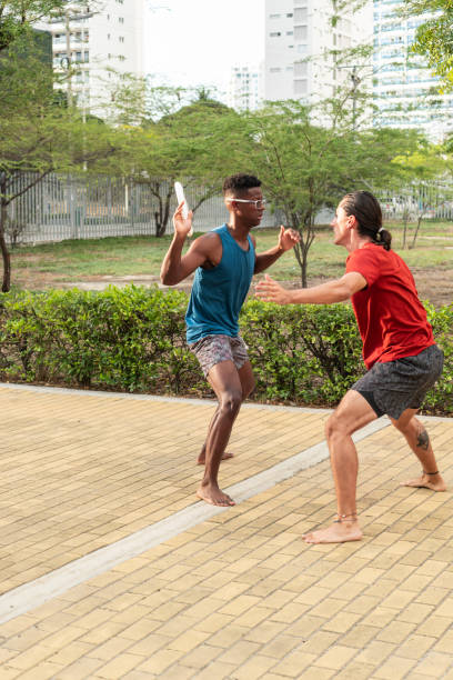 istock Two Men Playing Frisbee in a Sunny Urban Park 2157859690