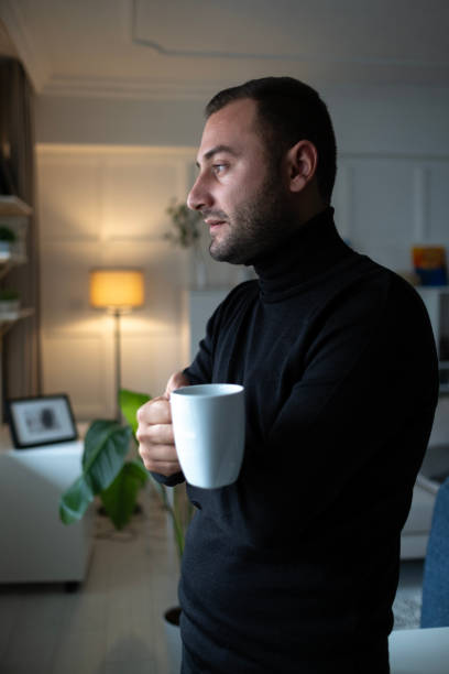 istock Thoughtful serious man sitting on sofa at home, lost in thoughts 2157860340