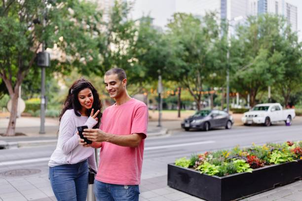 istock Man and woman looking at the smartphone while exploring the city 2157865473