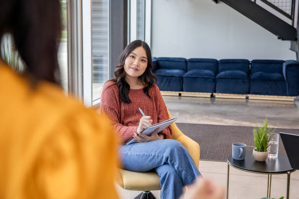 istock Young woman takes notes during meeting with diverse colleagues 2157866125