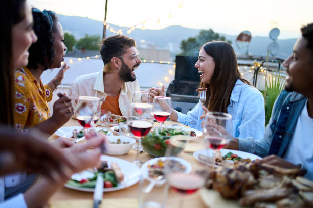istock Laughing multiracial young people sitting at table having fun during celebration barbecue outdoors. 2157872421