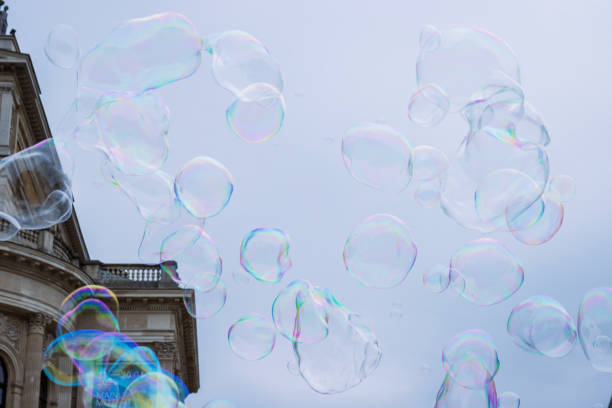 Captured in the heart of London, this vibrant photograph features a giant soap bubble mid-burst, reflecting a kaleidoscope of colors. The iconic Big Ben stands proudly in the blurred background, adding a touch of historical grandeur to the scene. The outstretched hands of a child, reaching for the fleeting bubble, symbolize the transient nature of joy and wonder. This image beautifully juxtaposes the timelessness of the city’s architecture with the ephemeral magic of a moment in time.