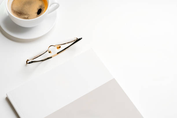 istock Blank paper, coffee cup and glasses on white desk 2157872891